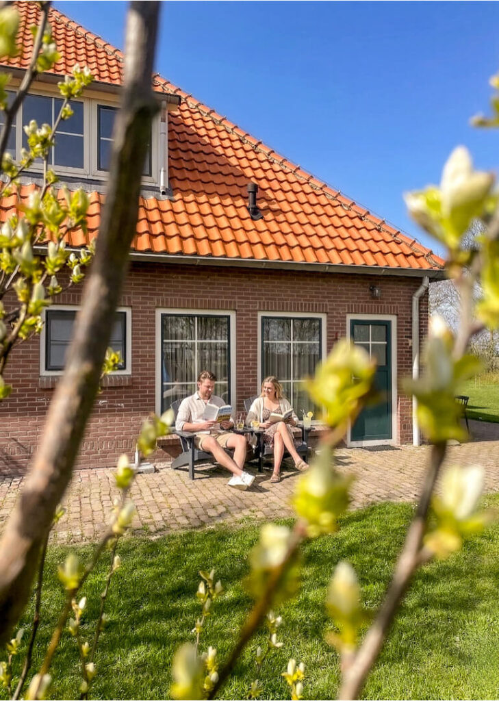 hoeve-vianen-2-4-personen-vakantiehuis-texel-buiten2 buitenfoto farm lodge hogezandskil met stel dat lekker buiten zit